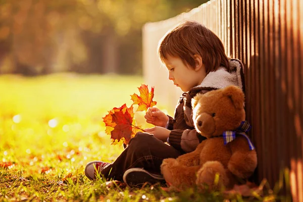 Adorable niño con osito de peluche en el parque — Foto de Stock