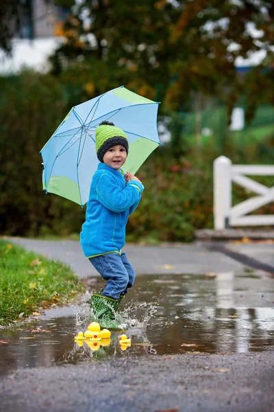 Little boy, jumping in muddy puddles — Stock Photo, Image