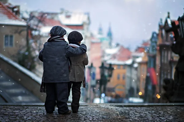 Two kids, standing on a stairs, hugging view of Prague in front — Stock Photo, Image