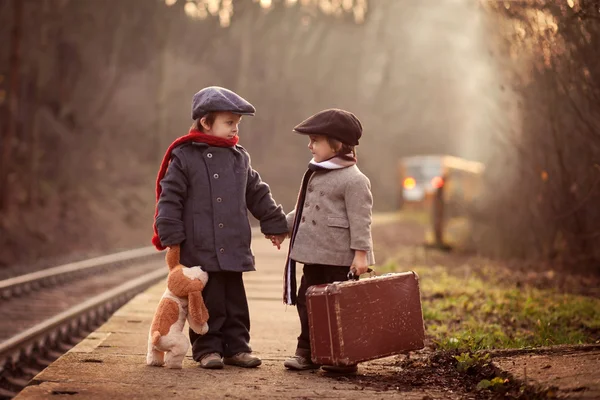 Dois rapazes numa estação ferroviária, à espera do comboio — Fotografia de Stock