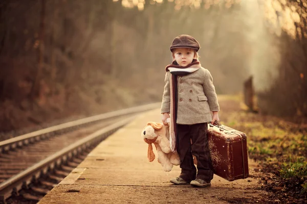 Menino adorável em uma estação ferroviária, esperando o trem — Fotografia de Stock