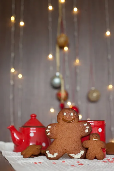 Smiling gingerbread man and a smaller one next to him standing i — Stock Photo, Image