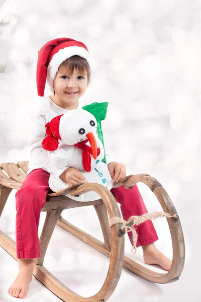 Ragazzo carino a Natale, divertirsi con il pupazzo di neve — Foto Stock