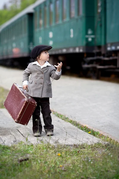 Niño, vestido con abrigo y sombrero vintage, con maleta — Foto de Stock