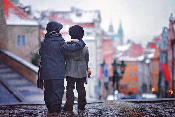 İki çocuk, bir merdiven üzerinde duran Prag onların arkasında, kar görüntülemek — Stok fotoğraf