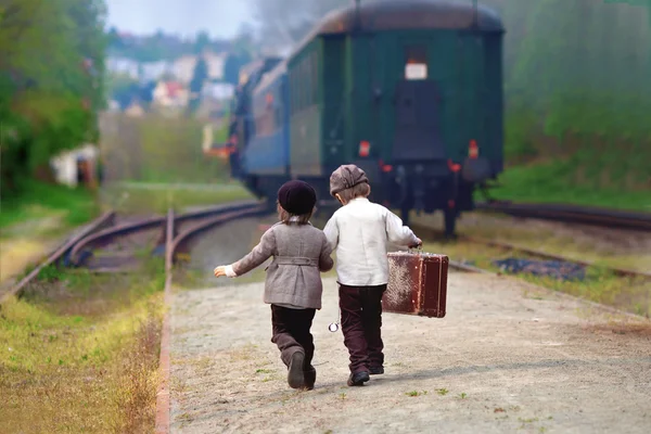 Twee jongens, gekleed in vintage kleding en hoed, met koffer — Stockfoto