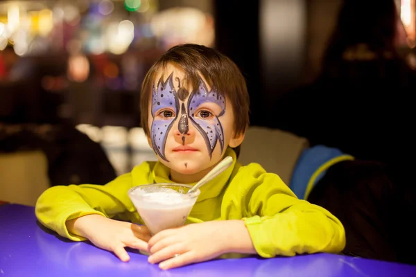 Niño con la cara pintada como butteffly, comiendo helado —  Fotos de Stock