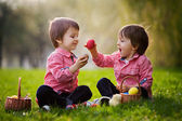 zwei Jungen im Park, die sich mit bunten Eiern zu Ostern vergnügen