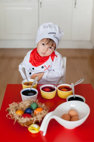 Маленький мальчик, раскрашивает яйца на Пасху — стоковое фото
