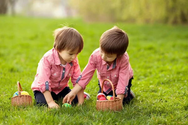 Zwei Jungen im Park, die sich mit bunten Eiern zu Ostern vergnügen — Stockfoto