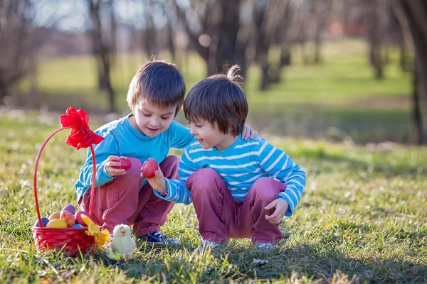 Zwei Jungen im Park, die sich mit bunten Eiern zu Ostern vergnügen — Stockfoto