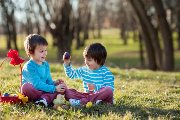 Dois meninos no parque, se divertindo com ovos coloridos para a Páscoa — Fotografia de Stock