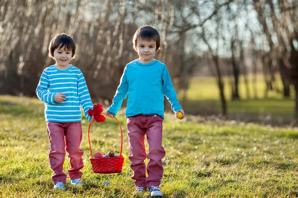 Two boys in the park, having fun with colored eggs for Easter — Stock Photo, Image