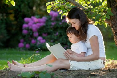 Anne ve çocuk, bir kitap yaz döneminde bir Bahçe, güzel güneş