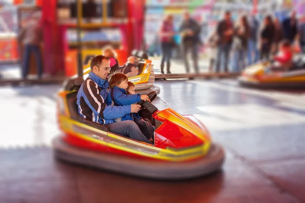 Father and his two sons,l having a ride in the bumper car at the — Stock Photo, Image
