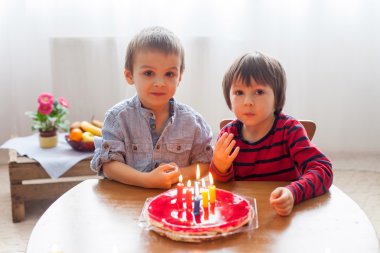 Sevimli sevimli çocuklar, mumlar bir doğum günü pastası üfleme