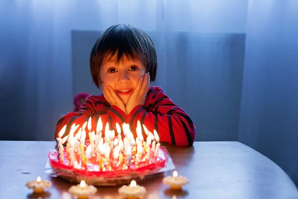 Adorable chico lindo, soplando velas en un pastel de cumpleaños — Foto de Stock