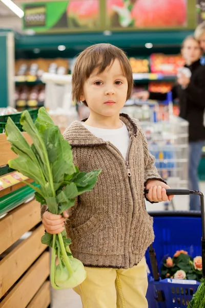 Bonito menino pequeno e orgulhoso ajudando com compras de supermercado, saudável — Fotografia de Stock