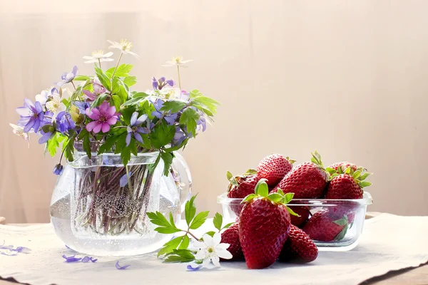 Szklany wazon z świeże wiosenne kwiaty las, miski z strawberr — Zdjęcie stockowe