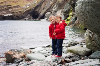 Kamera, smili arayan iki erkek okyanusun kıyısında