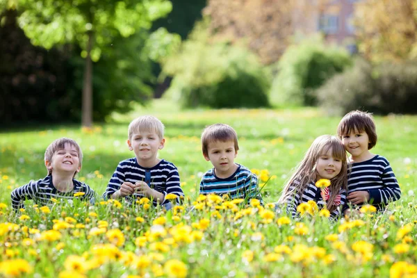 Five adorable kids, dressed in striped shirts, hugging and smili — Stockfoto