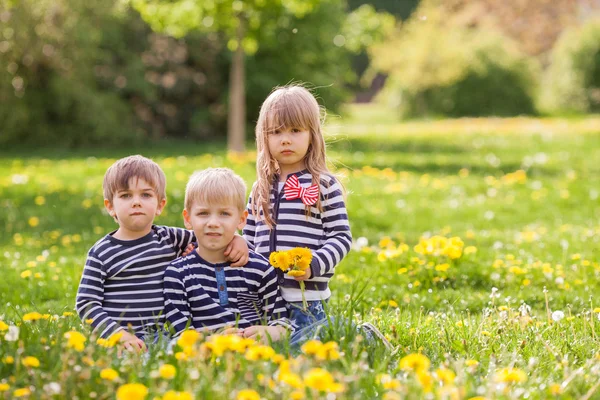 Three adorable kids, dressed in striped shirts, hugging and smil — Stock Photo, Image