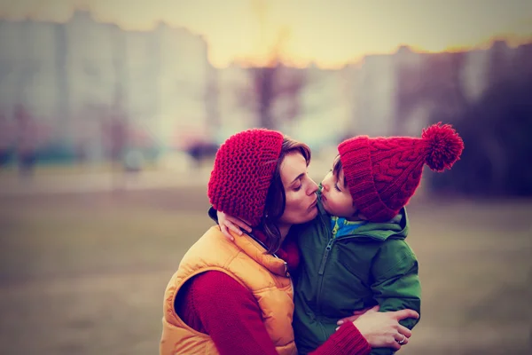 Mãe e filho, abraçando ao ar livre em um dia de inverno — Fotografia de Stock