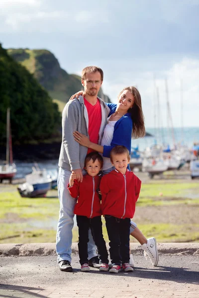 Familia joven con niños pequeños en un puerto por la tarde — Foto de Stock