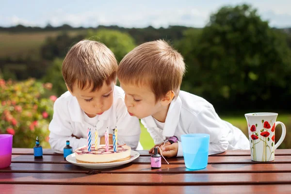 Urocza chłopców, dmuchanie świeczki na urodziny tort — Zdjęcie stockowe
