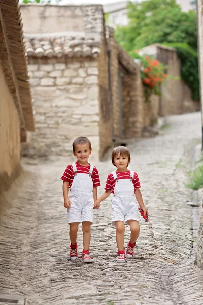 Dos niños adorables, caminando por la calle, sonriendo a la cámara —  Fotos de Stock