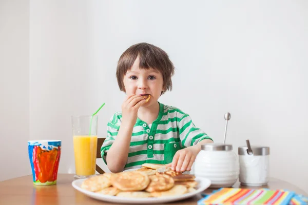 Dulce niño caucásico, comiendo panqueques — Foto de Stock