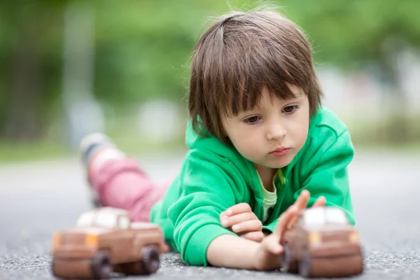 Αστεία μικρό αγόρι που παίζει με το αυτοκίνητό της σοκολάτας, εξωτερική — Φωτογραφία Αρχείου