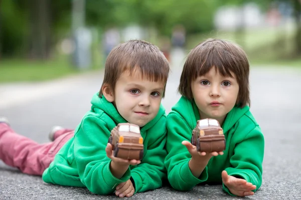 Rolig liten pojke leker med bil av choklad, utomhus — Stockfoto