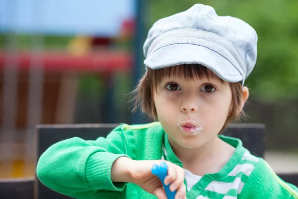 ヨーグルトを食べるかわいい笑顔若い子 — ストック写真