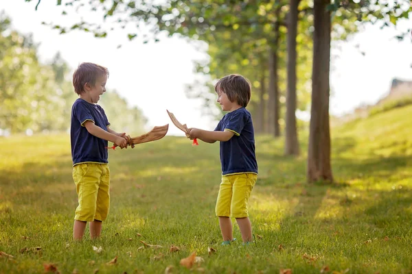 Two little boys, holding swords, glaring with a mad face at each — Stock Photo, Image