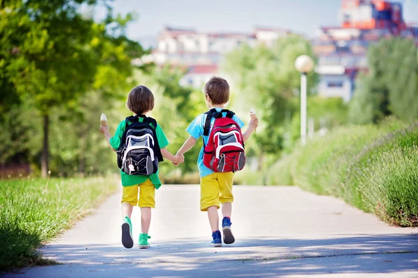 İki sevimli çocuk AWA yürüyüş renkli giysiler ve sırt çantaları, — Stok fotoğraf