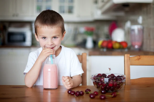 Glücklicher Schuljunge, der einen gesunden Smoothie als Snack trinkt — Stockfoto