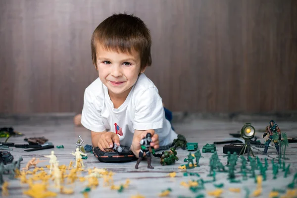 Bonito menino criança, brincando em casa com soldados e figura — Fotografia de Stock