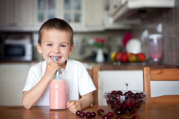 Glad skolpojke dricker en hälsosam smoothie som mellanmål — Stockfoto