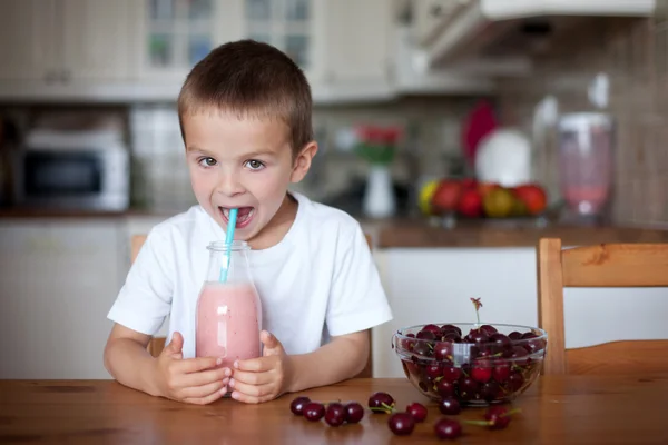 Glücklicher Schuljunge, der einen gesunden Smoothie als Snack trinkt — Stockfoto