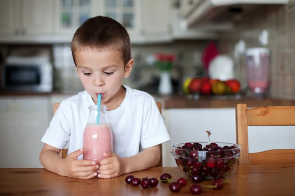 Glücklicher Schuljunge, der einen gesunden Smoothie als Snack trinkt — Stockfoto