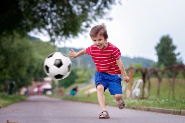 Birlikte futbol oynayan iki sevimli küçük çocuk, yaz