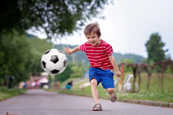 Dois miúdos giros, a jogar futebol juntos, no Verão. — Fotografia de Stock