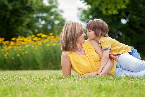 Young beautiful mom and her cute little boy, relaxing and having