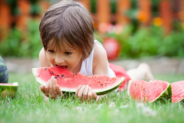 Junge, Wassermelone essen im Garten, Sommer — Stockfoto