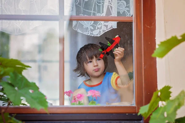 Menino doce, brincando com avião no início da manhã — Fotografia de Stock