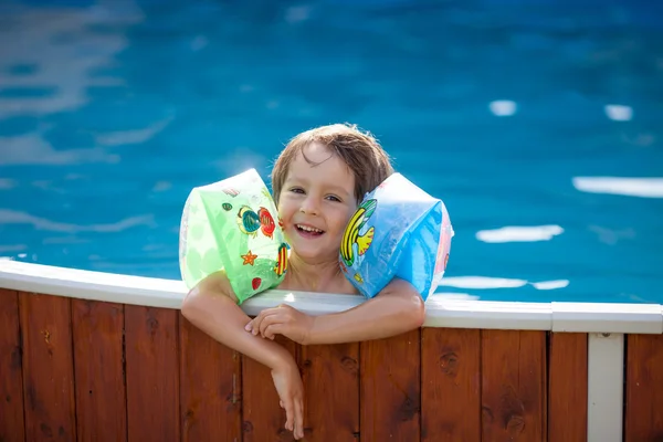 Sweet little boy, swimming in big swimming pool — Stock Photo, Image