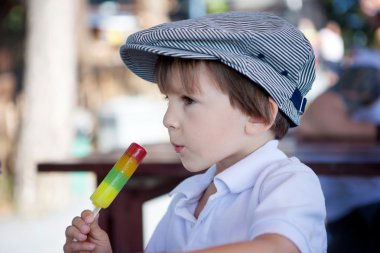 Cute sweet boy, child, eating colorful ice cream in the park clipart