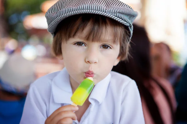 Bonito menino doce, criança, comer sorvete colorido no parque — Fotografia de Stock