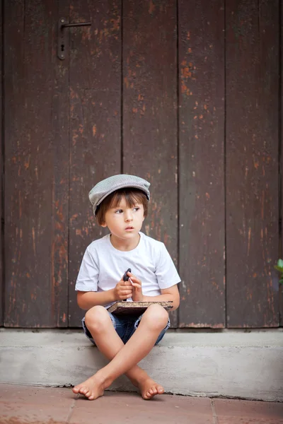 Cute little child, boy, holding big metal key and a book, willin — Zdjęcie stockowe